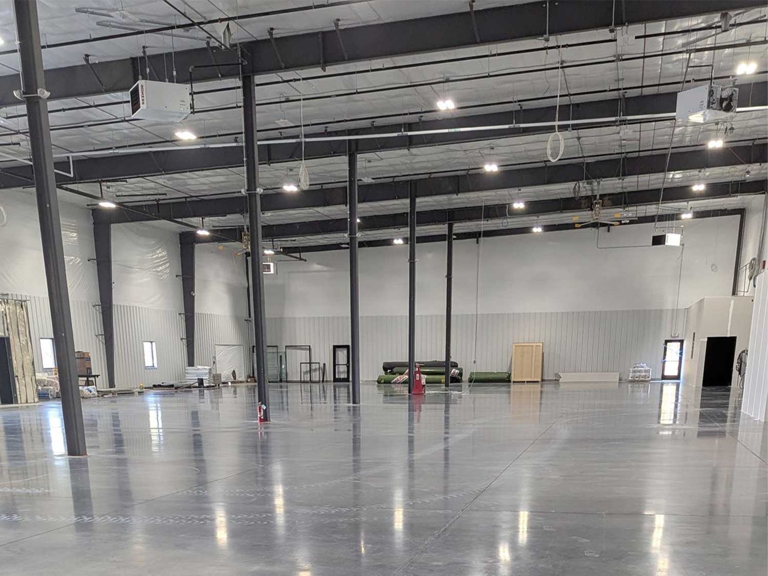 Empty steel-frame arena with polished concrete floor before the United Sports Arena fit-out