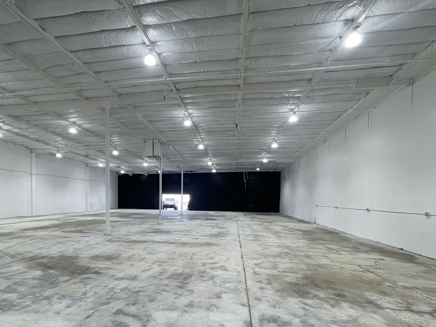Empty white warehouse with bare concrete floor before the Strikers Academy fit-out