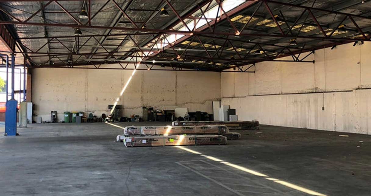 Disused brick warehouse with bare concrete floor before conversion