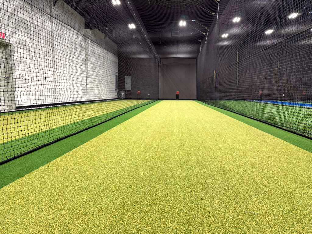 Netted indoor cricket practice lanes with turf after conversion