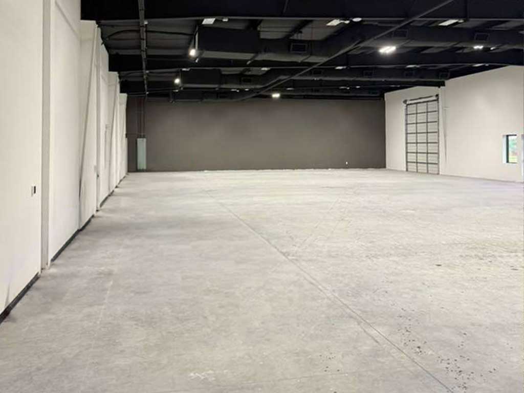 Empty commercial unit with bare concrete floor before conversion